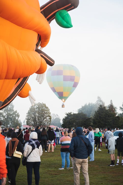Audience Watching a Hot Air Balloon Rising from a Foggy Landing Field