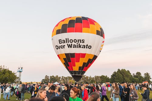 Hot Air Balloon with the Name of the Festival on a Crowded Landing Field