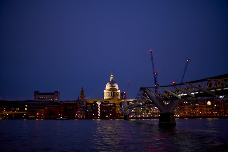 Millennium Bridge Over The River Thames And St Pauls Cathedral Illuminated At Night In London