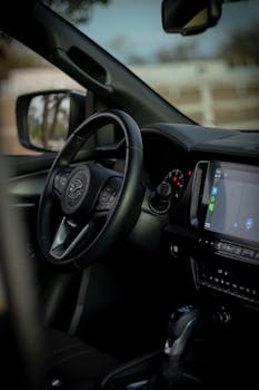 Close-up view of a car interior showcasing the steering wheel and dashboard screens in a modern vehicle.