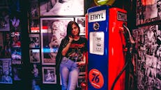 一名妇女在装饰着玛丽莲·梦露照片的复古加油泵旁摆姿势