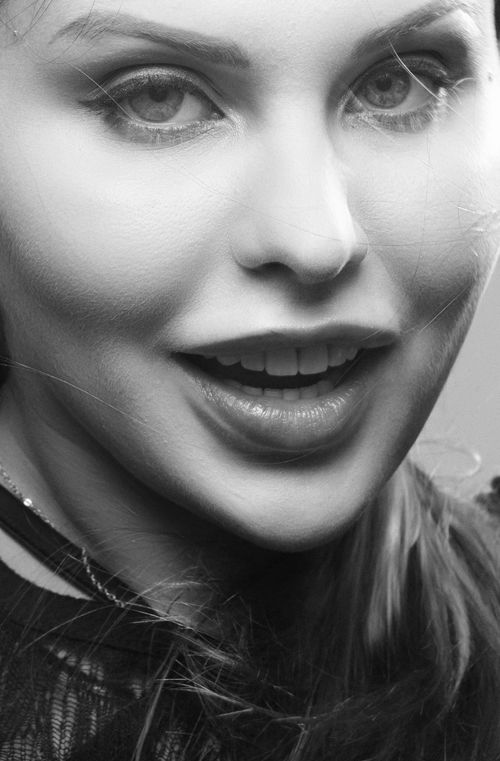 Free Artistic black and white portrait featuring a smiling woman with expressive eyes. Stock Photo