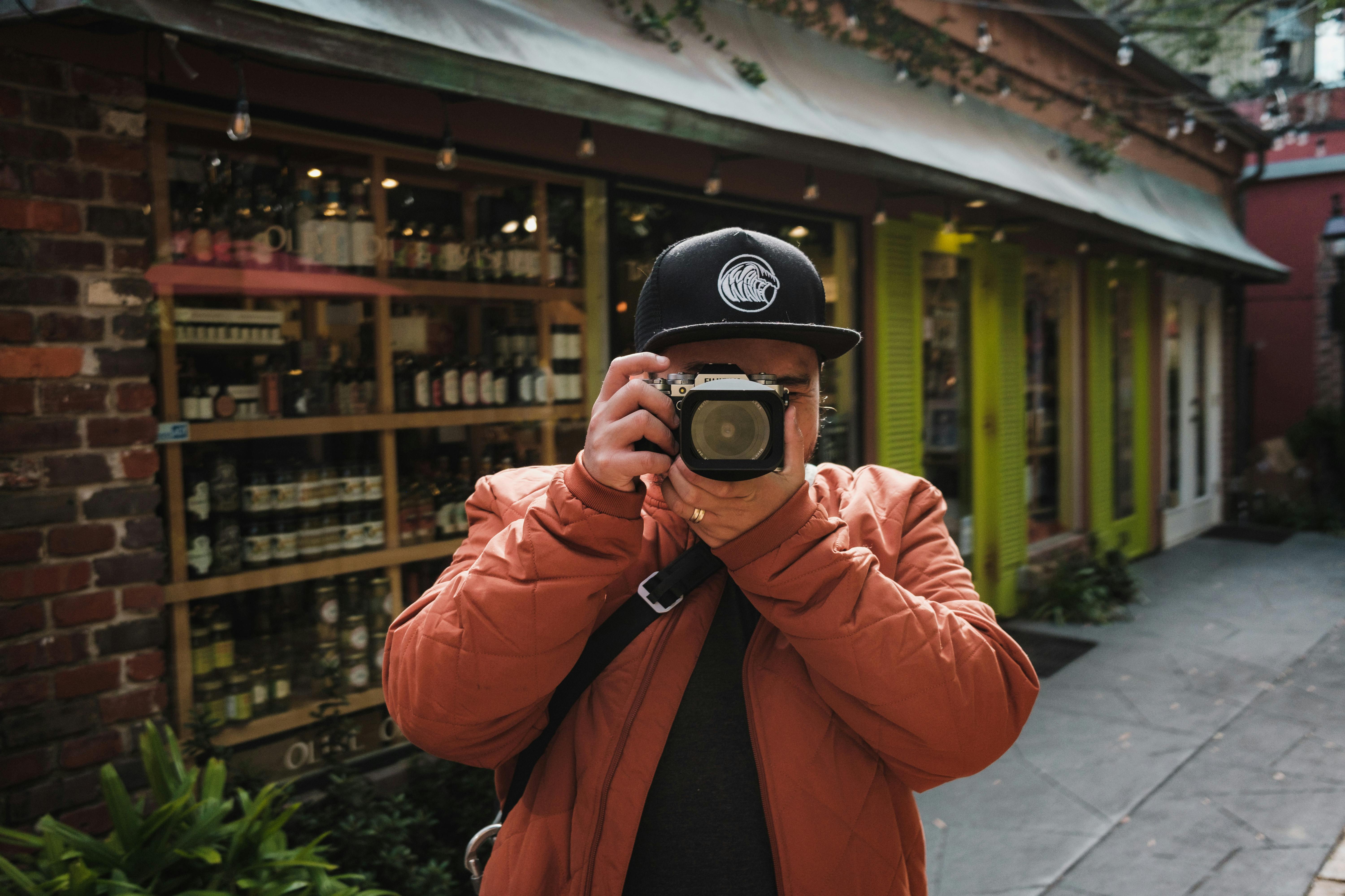 man in cap taking pictures with camera