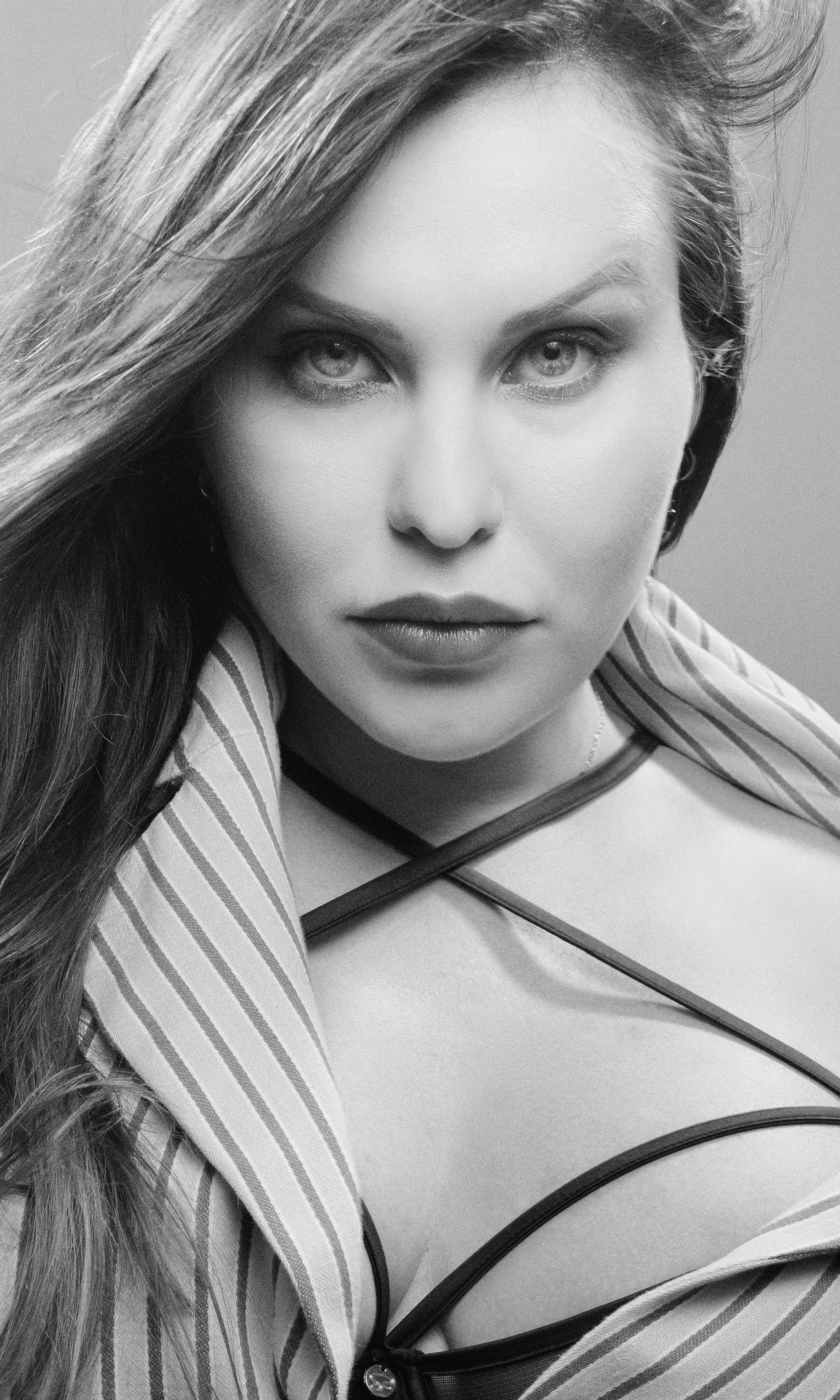 A captivating black and white portrait of a woman with long hair posing confidently.