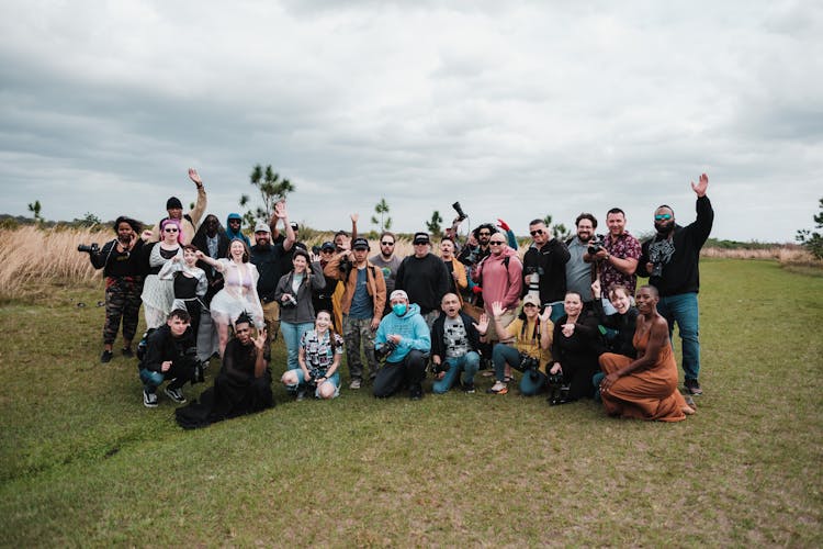 People Posing Together And Waving