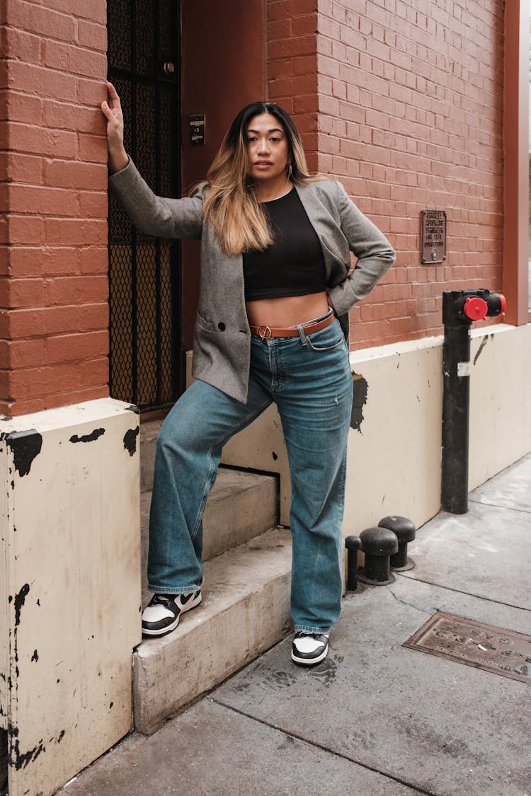 Woman In Casual Clothes Posing Near Building Entrance