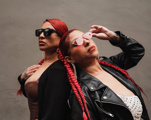 Redhead Women in Sunglasses Posing near Wall