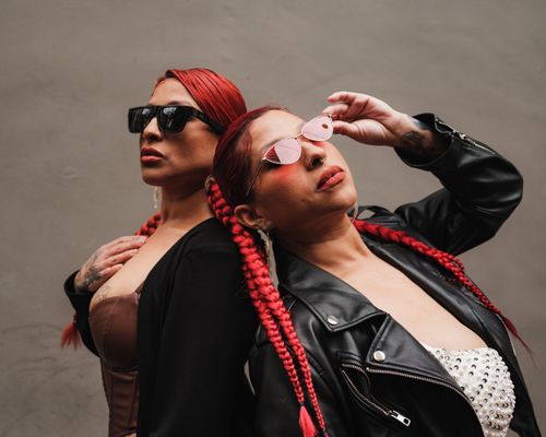 Free Two fashionable women with red braided hair and sunglasses striking a confident pose. Stock Photo