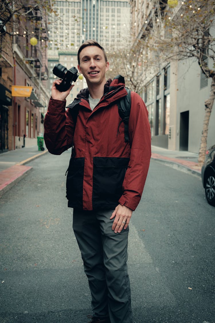 Smiling Man With Camera On City Street