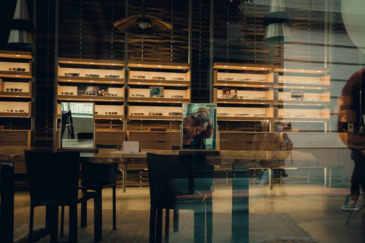 Man Taking Picture In Mirror In Cafe