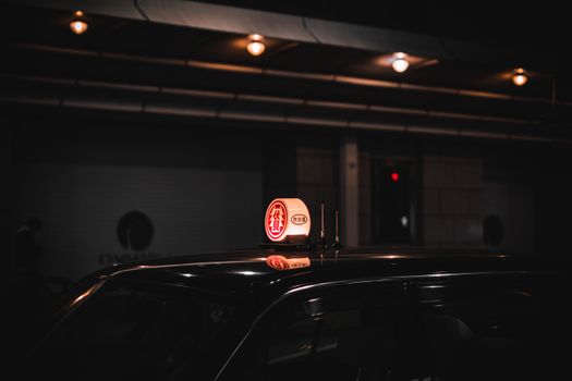Moody night shot of a taxi in urban Japan, emphasizing streetlights and serene ambiance.