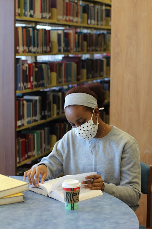 Woman Reading a Book in a Library