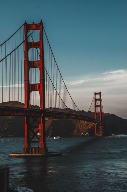 Free Stunning view of the Golden Gate Bridge at sunset, capturing the iconic San Francisco landmark over the serene waters. Stock Photo