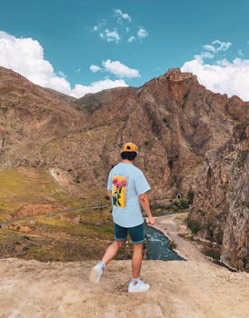A man stands on a rocky hill in Divriği, Sivas, enjoying the scenic view.