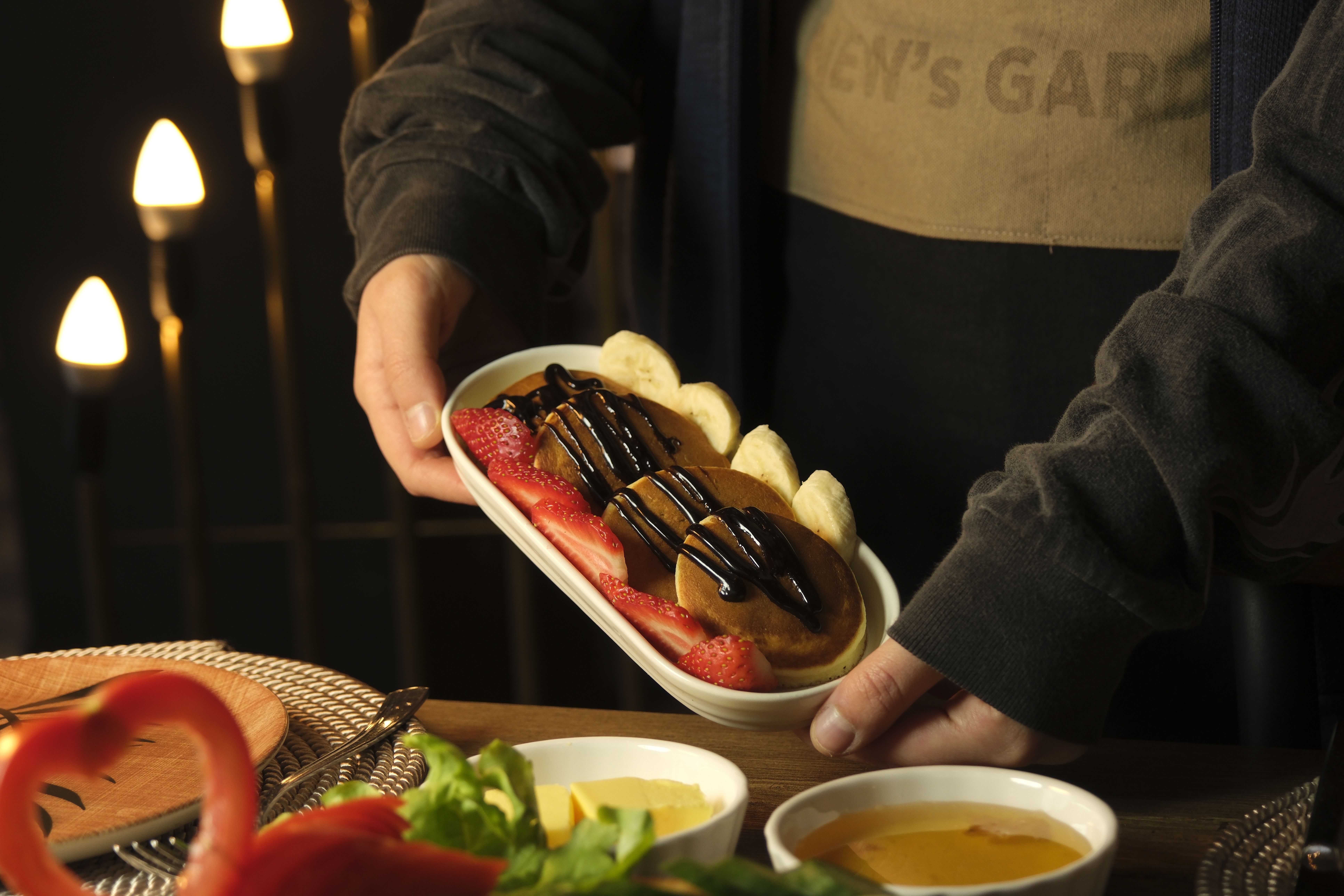 Free Close-up of pancakes topped with chocolate, strawberries, and bananas, perfect for a sweet treat. Stock Photo