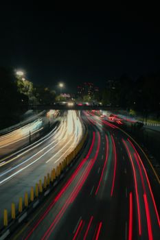 Long exposure capturing vibrant city lights and motion on a Mexico City highway at night.