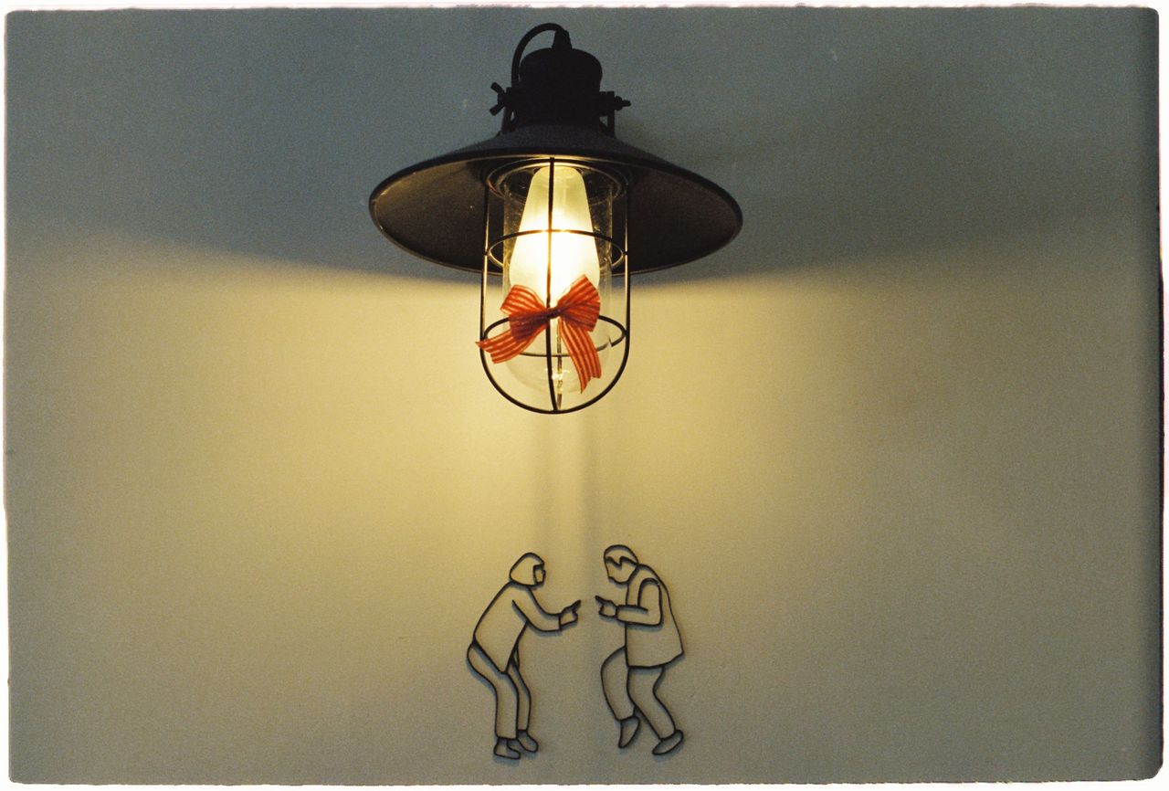 vintage lamp with light bulb and art figures on a wall creates a uniqu