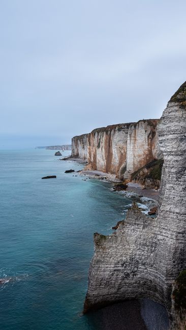 Explore the stunning cliffs of Étretat, France, captured on a serene and overcast day.