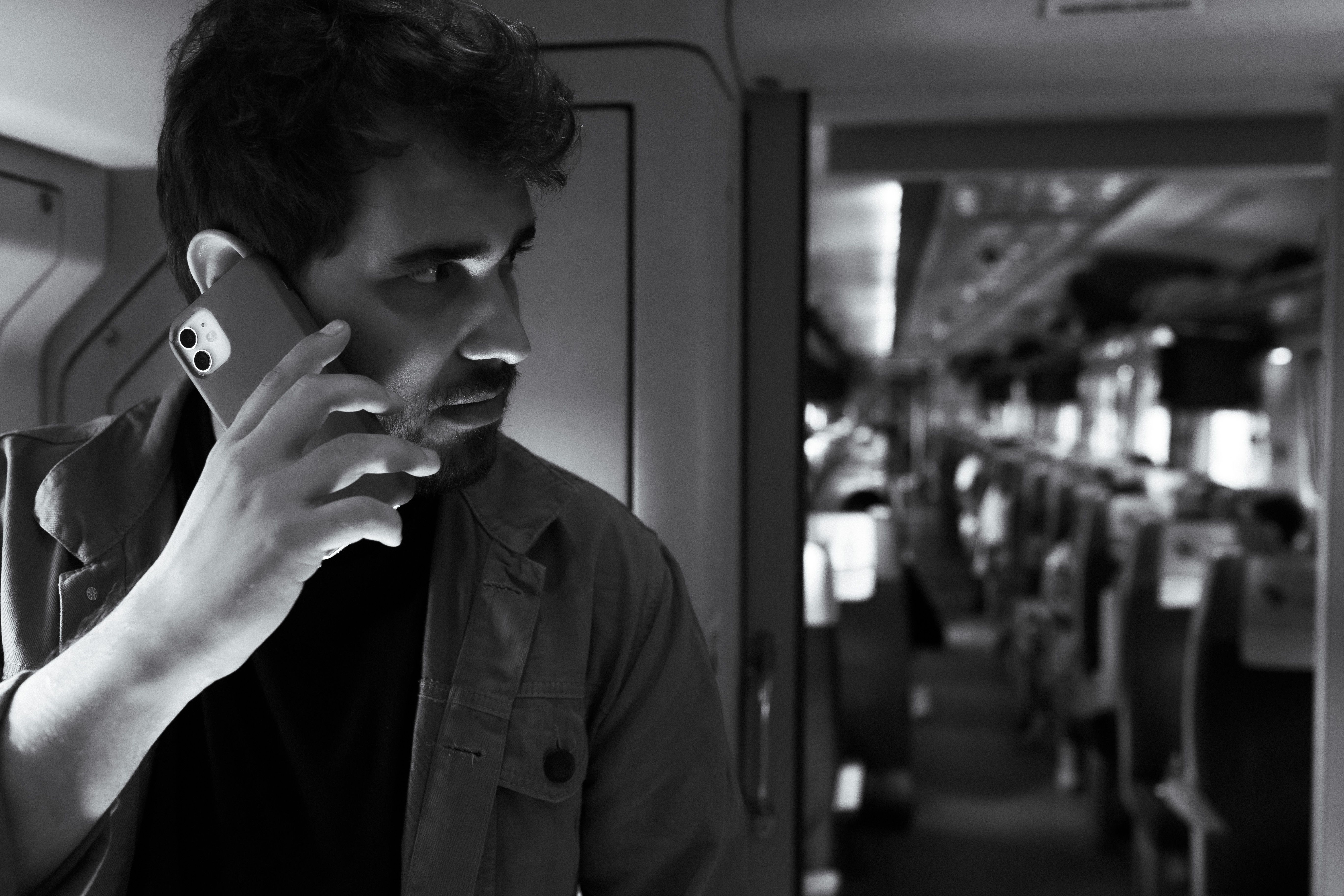 Hombre en un vagón de tren usando su teléfono — el modo durante el viaje en acción