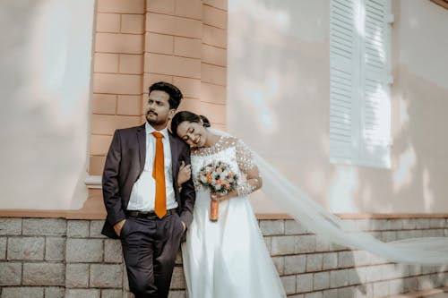 Bride and Groom Standing Together in front of a Building 