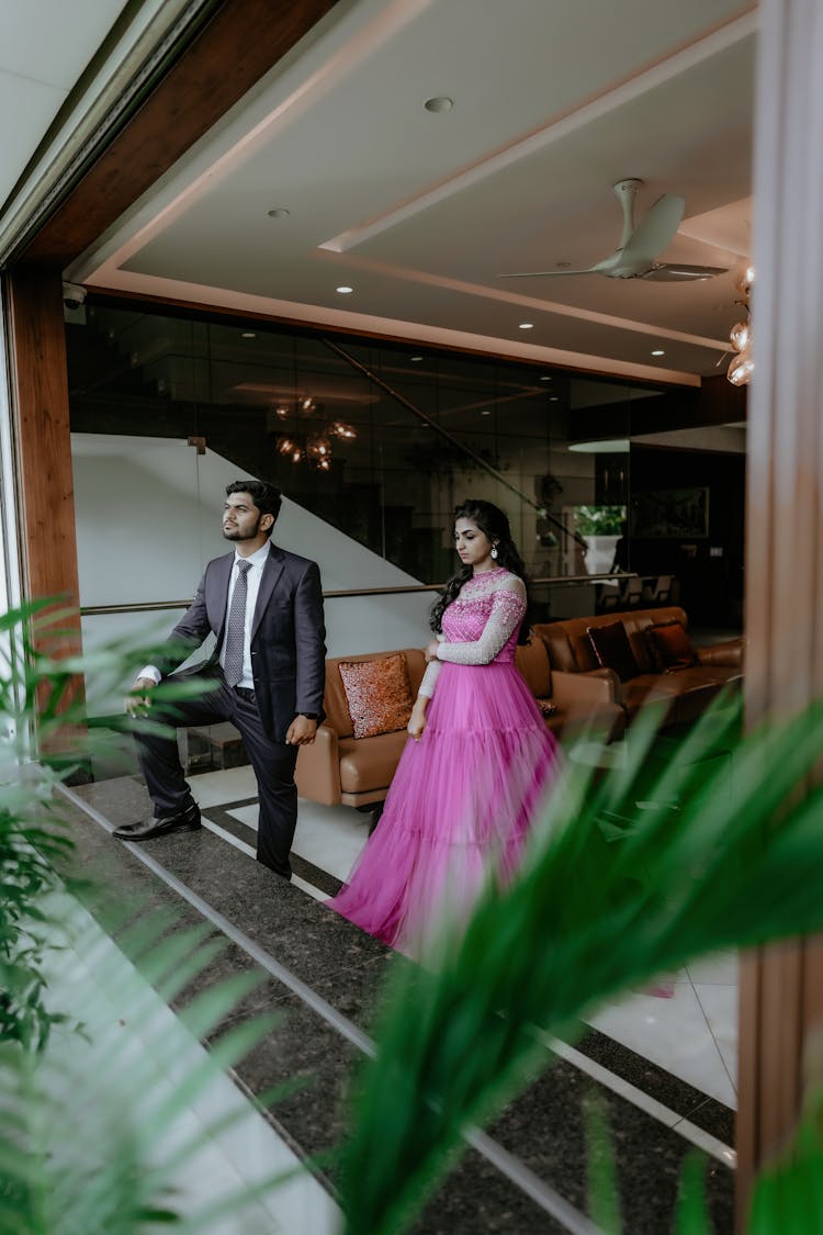 Man In Suit And Woman In Dress Standing In Room