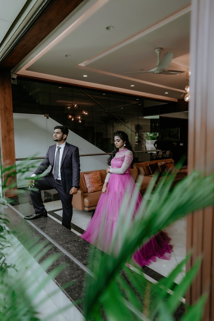 Woman In Pink Dress And Man In Suit Standing In Room