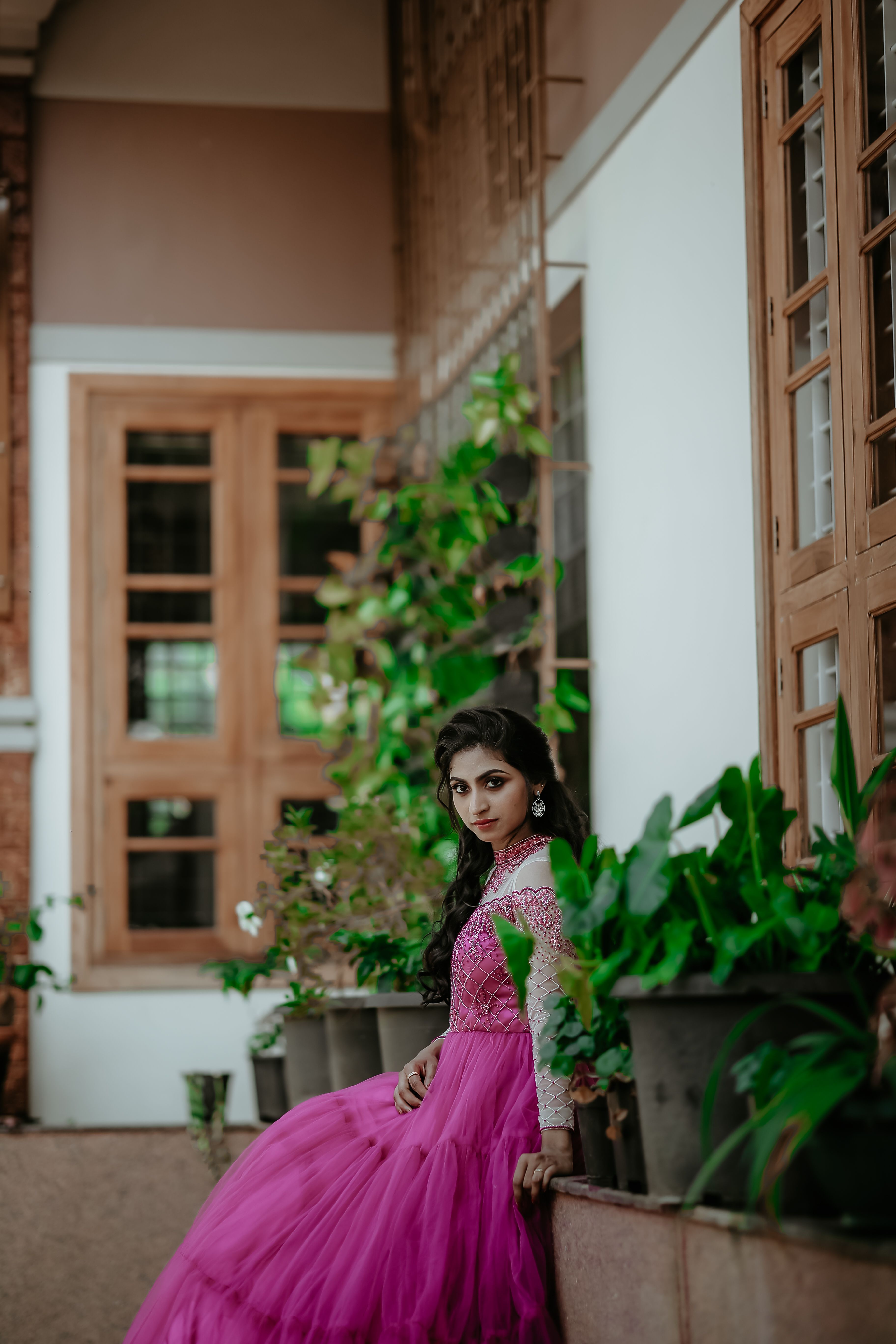 Brunette Woman in Pink Dress Posing on Wall · Free Stock Photo