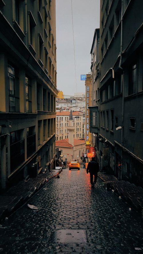 Free A rainy, narrow cobblestone street in Istanbul with a city view, capturing urban ambiance. Stock Photo