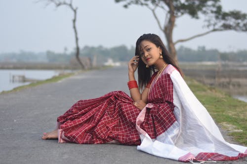 Woman in Traditional Dress Sitting on Road