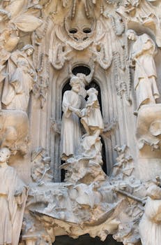 Close-up view of detailed religious sculptures on La Sagrada Familia's facade in Barcelona.