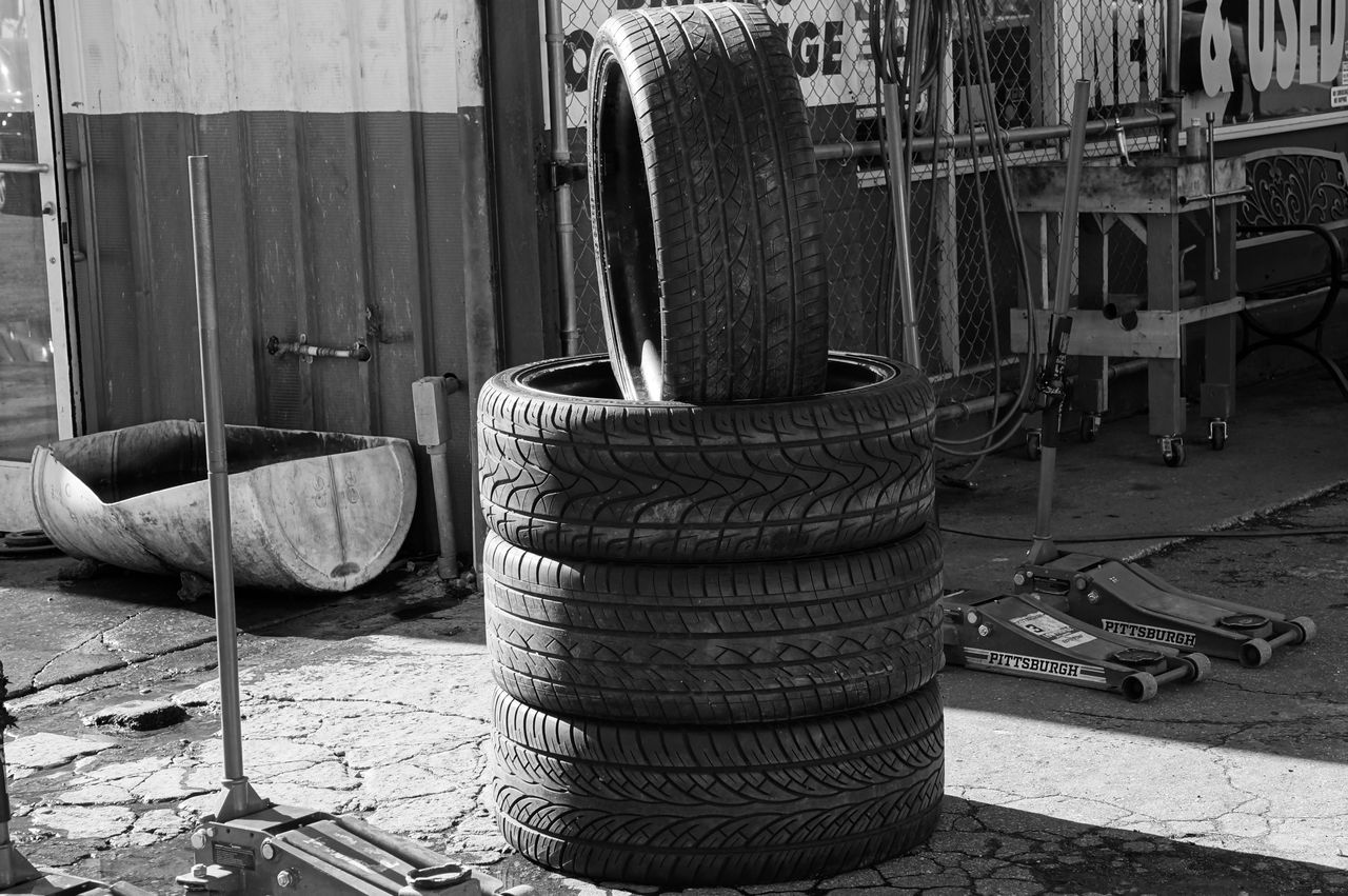 Gestapelte Reifen in einer Garage mit industrieller Atmosphäre.