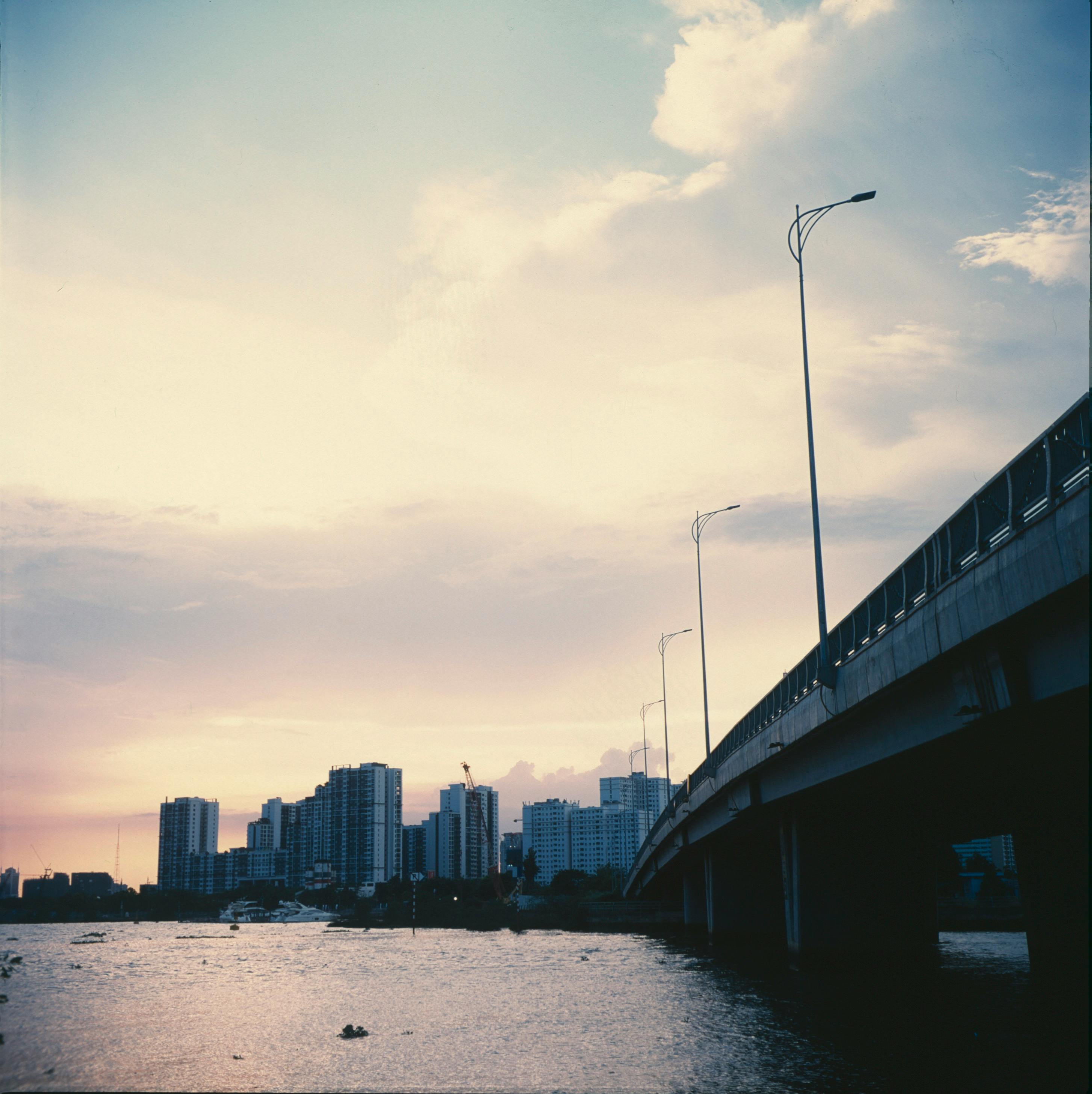 Beautiful city skyline with a bridge over water during a vibrant sunset.