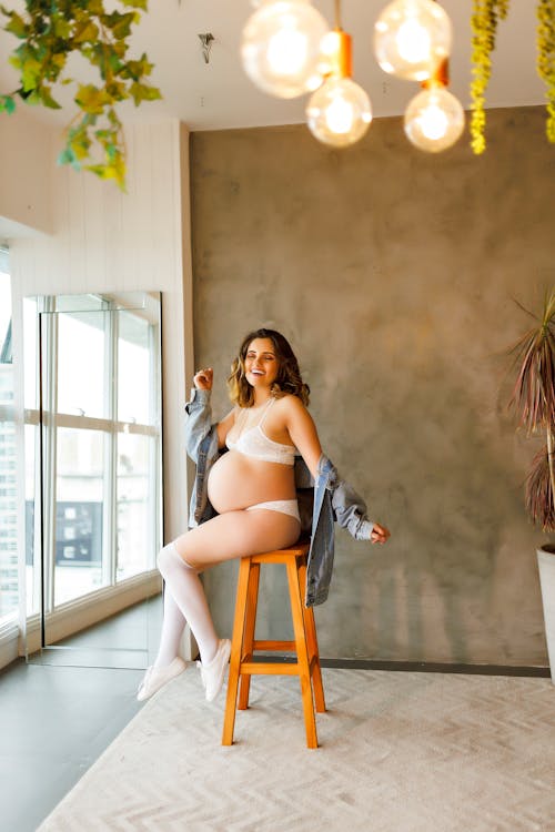 Smiling Pregnant Woman Posing On Chair At Office Stock Photo, Picture and  Royalty Free Image. Image 81038396.