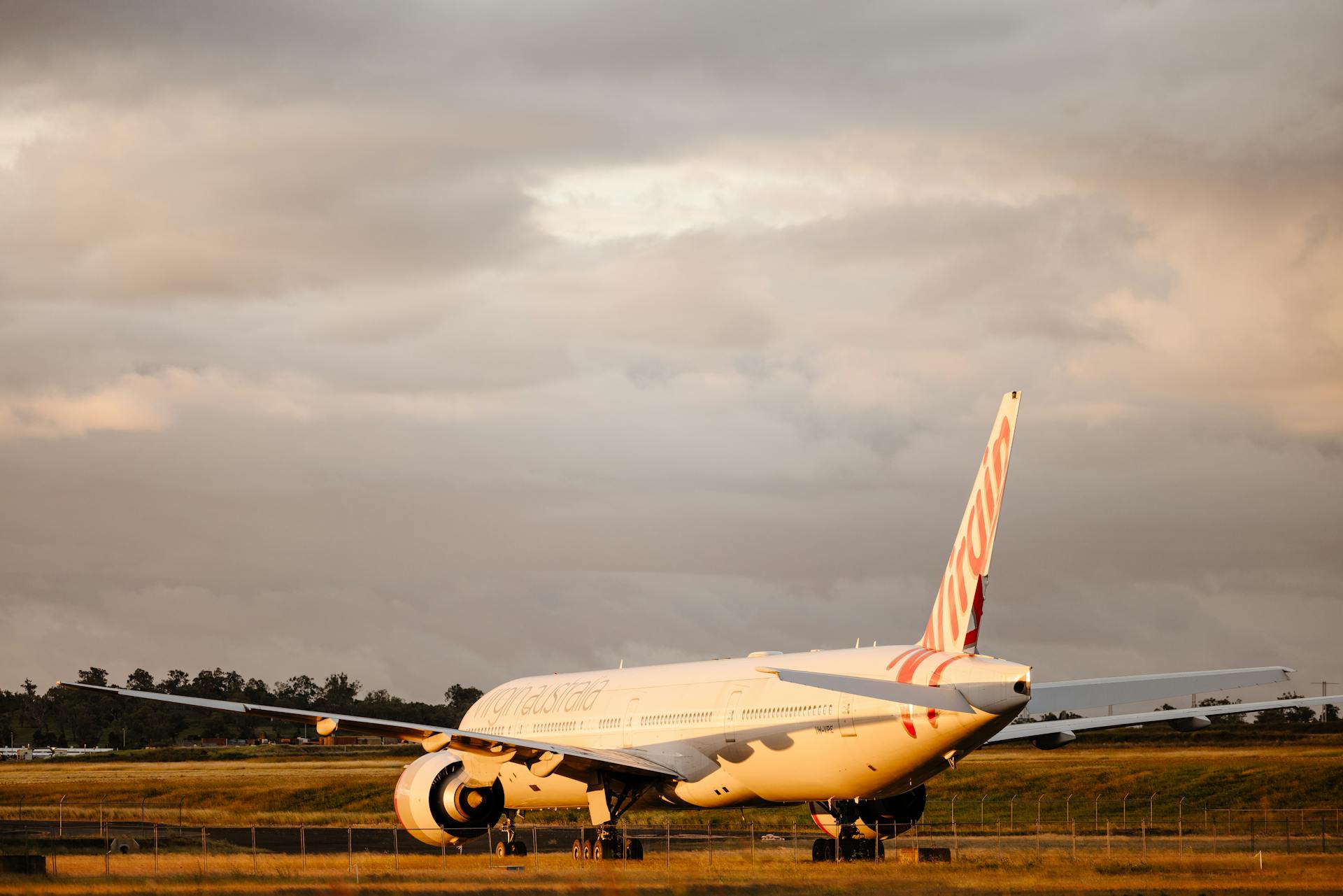 Virgin Australia Boeing 777 on tarmac at Wellcamp Airport during golden hour.