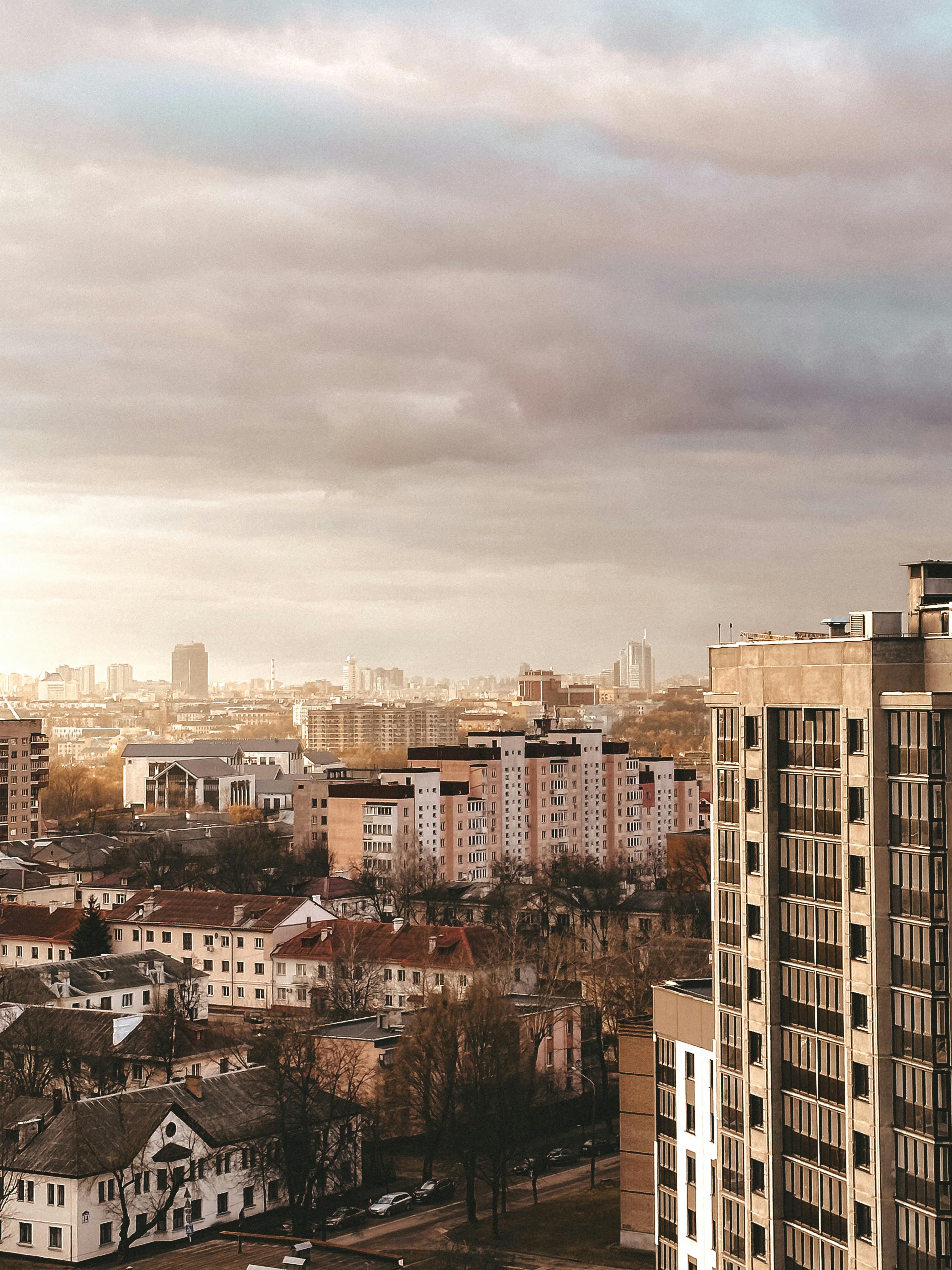 Aerial view of urban residential area with diverse architecture under a cloudy sky.