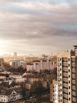Aerial view of urban residential area with diverse architecture under a cloudy sky.