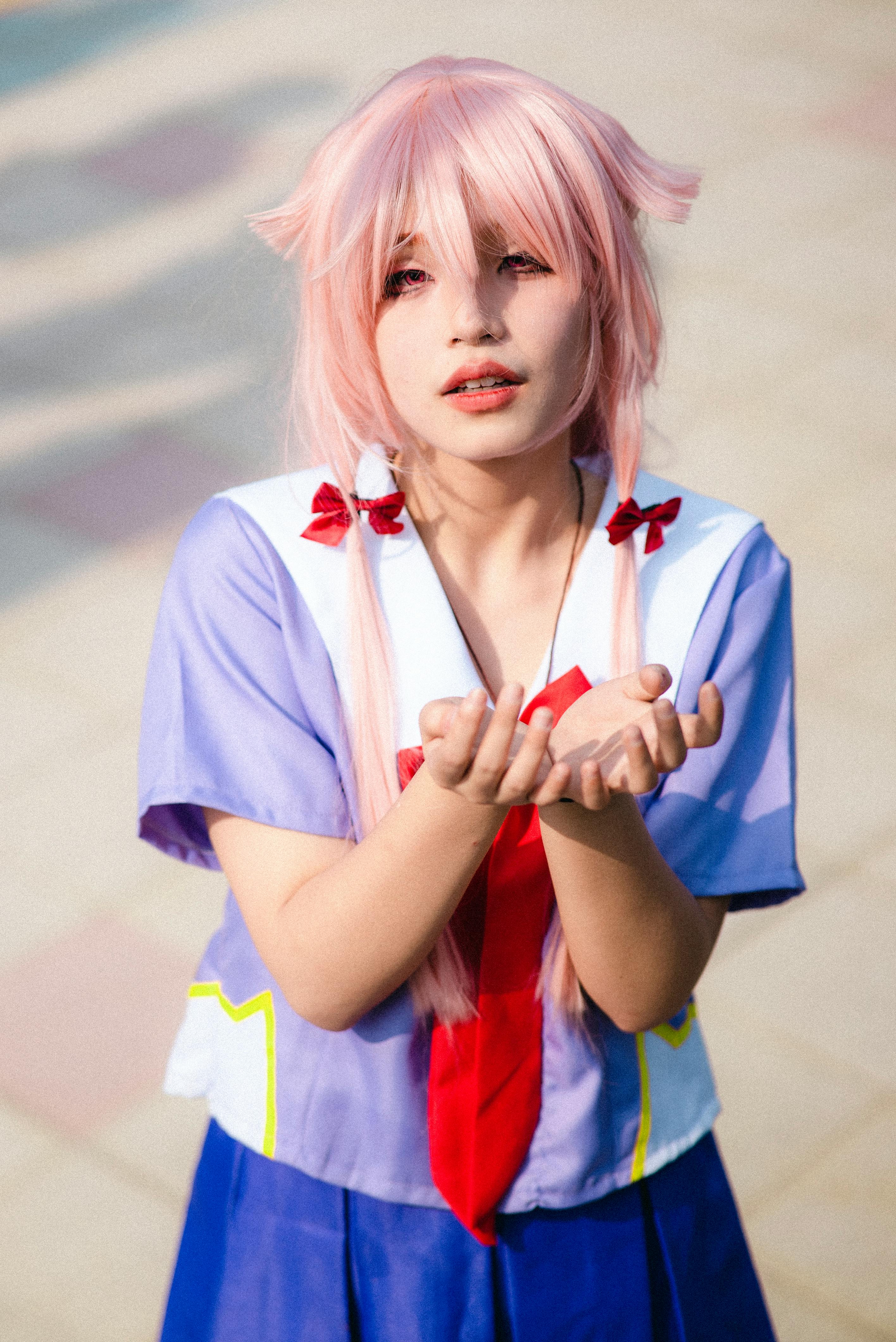 girl in a school uniform holding up her hands