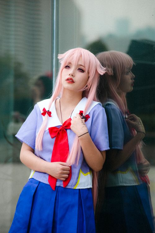Free Young woman in anime schoolgirl outfit with pink hair reflects on window. Stock Photo