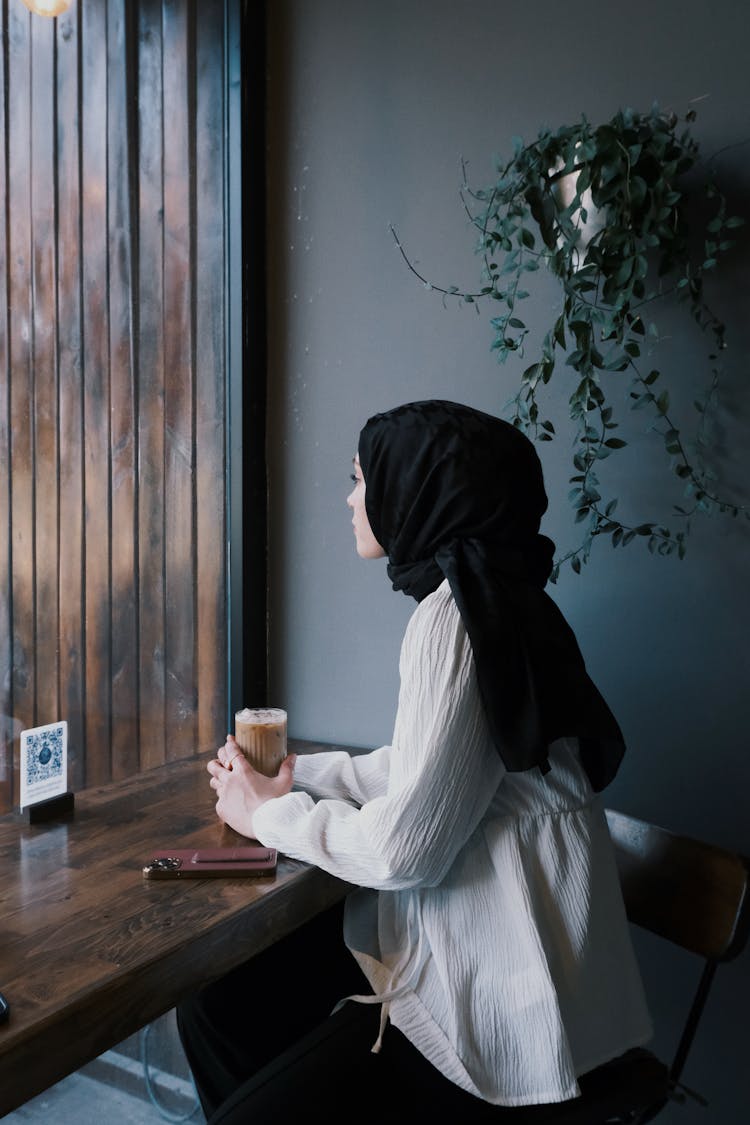 Woman Sitting With A Coffee At The Bar Table