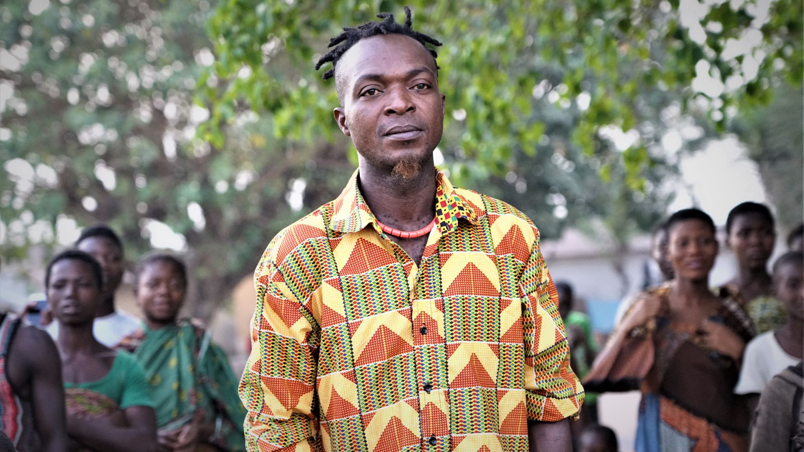 Man in shirt standing by group of people, Togo