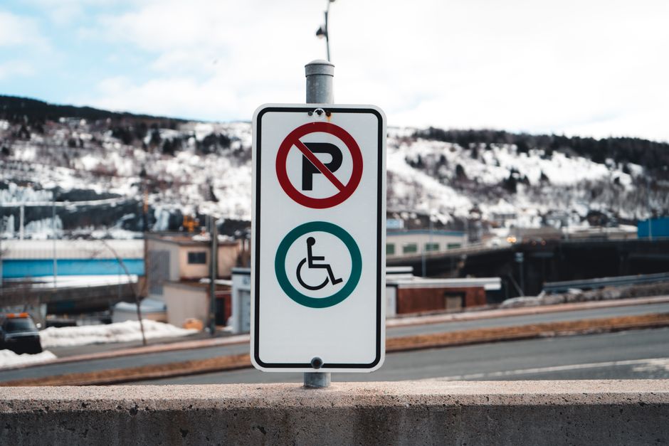 building effective feedback loops for professional growth - A no parking and accessible sign in a snowy urban setting with mountain background.