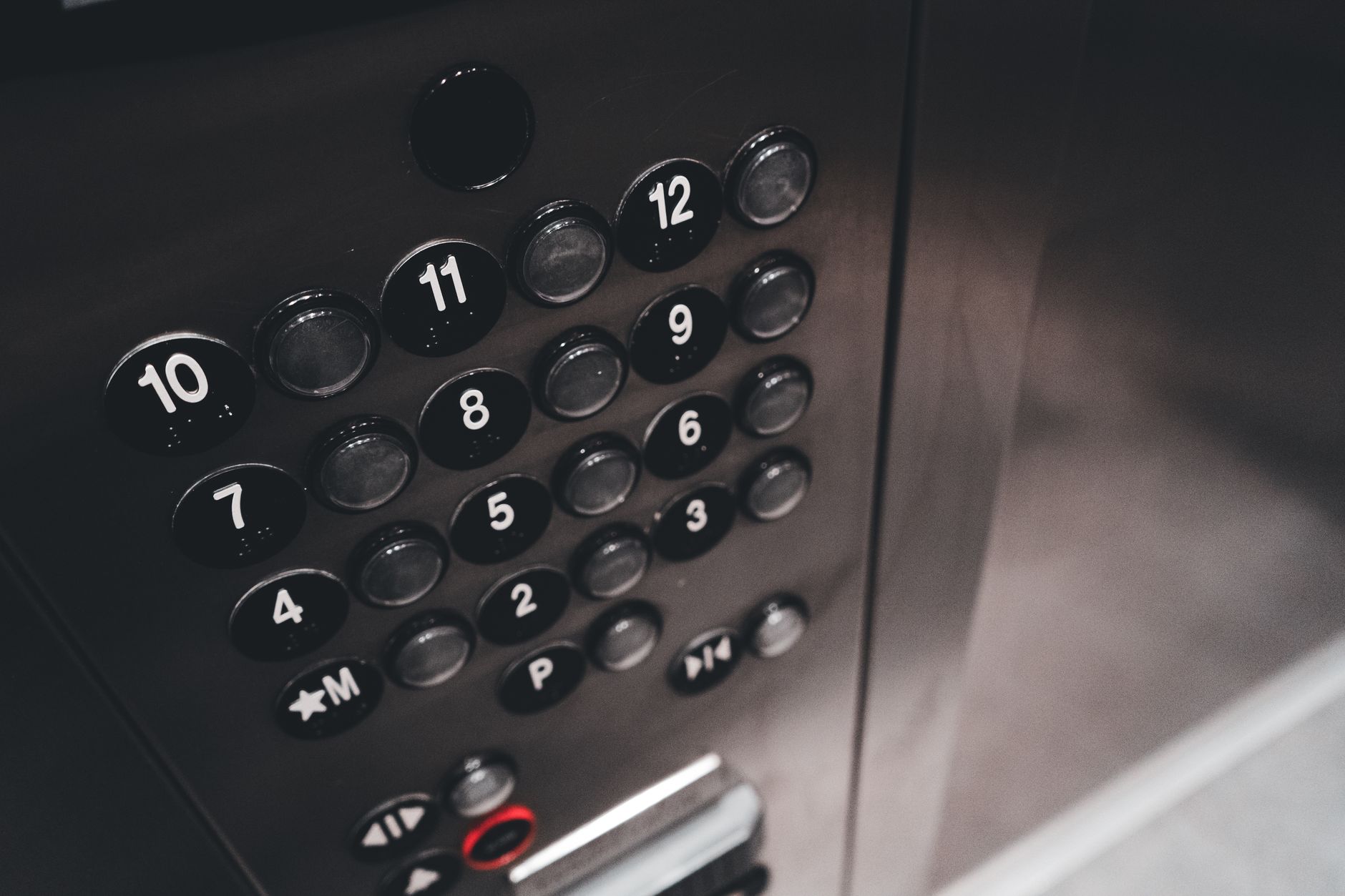 Detail view of a sleek elevator control panel with metallic finish and numbered buttons.