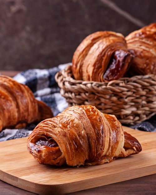 Free Freshly baked croissants on a wooden board, showcasing their flaky perfection. Stock Photo