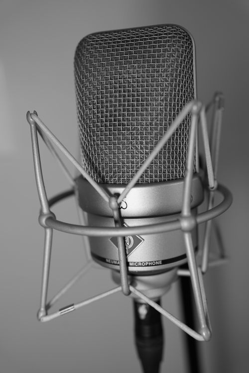 Free Close-up of a high-end condenser microphone in black and white, ideal for studio recording. Stock Photo