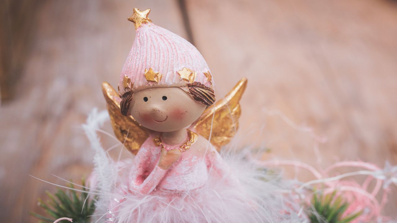 a cute christmas angel figurine in pink and gold perfect for festive d