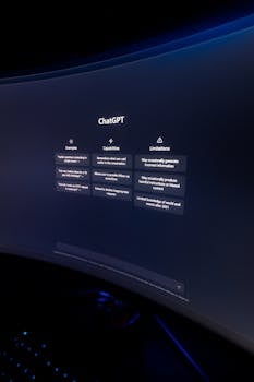 Close-up of ChatGPT's interface displayed on a curved monitor in a dimly lit environment.