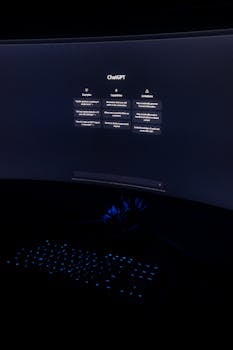 Curved computer monitor displaying ChatGPT interface in a dimly lit room with a glowing keyboard.