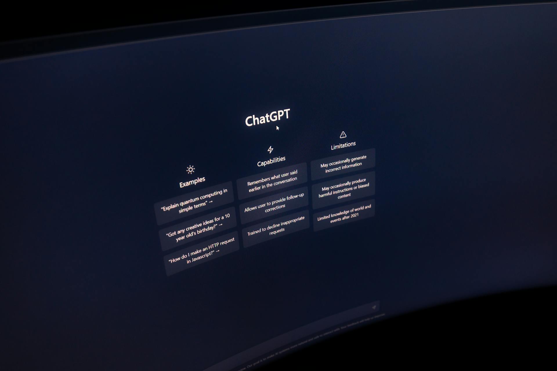 Close-up of a computer screen displaying ChatGPT interface in a dark setting.