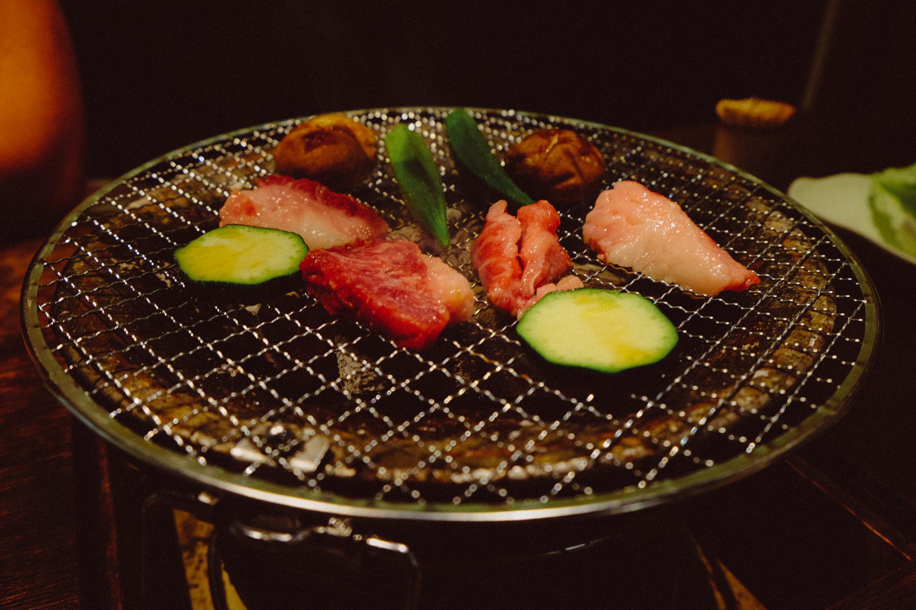 Appetizing grilled meat and vegetables sizzling on a traditional indoor charcoal grill.