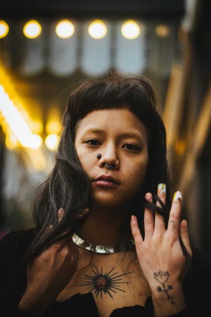 Portrait of a woman with tattoos and piercings in Portland, OR. Captivating urban aesthetic.